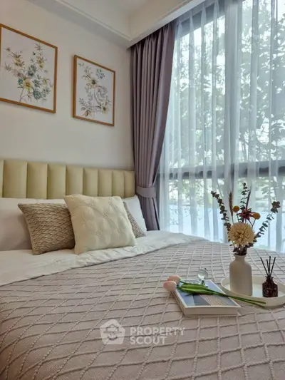 Elegant bedroom with large window, stylish decor, and cozy bedding in modern apartment.