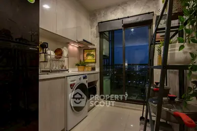 Modern kitchen with sleek appliances and city view from balcony.
