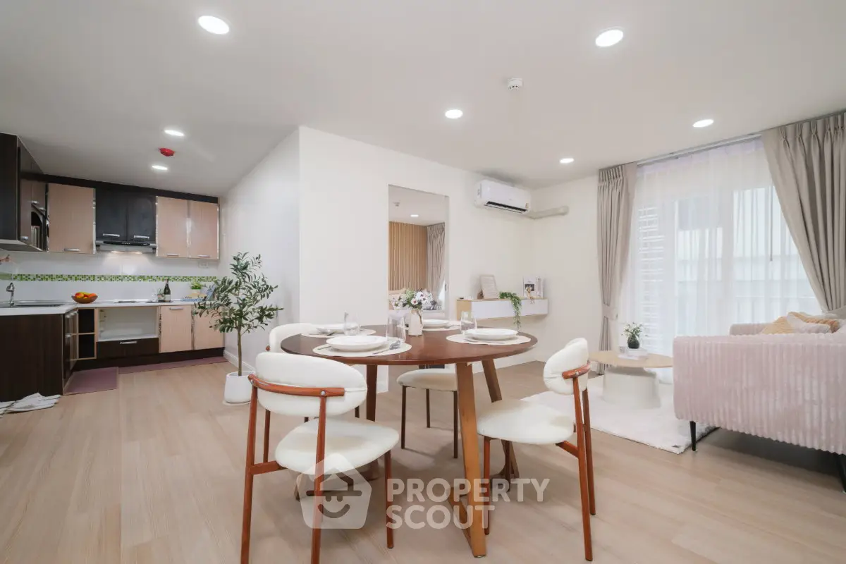 Spacious open-plan living and dining area with modern kitchen and elegant decor.