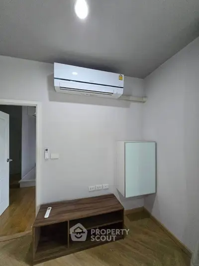 Minimalist room with air conditioning and wooden flooring, perfect for modern living.