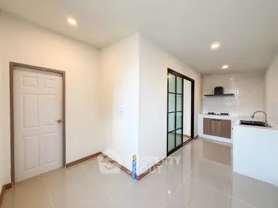 Modern kitchen with sleek design and open layout, featuring glossy tiles and contemporary cabinetry.