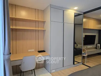 Modern bedroom with built-in wardrobe and study desk, featuring sleek design and ample storage space.