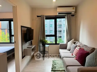 Cozy living room with modern decor and large window view in urban apartment.