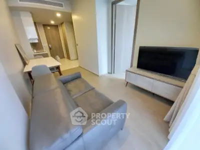 Modern living room with sleek furniture and open kitchen layout in a stylish apartment.