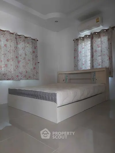 Cozy bedroom with floral curtains and air conditioning, perfect for restful nights.