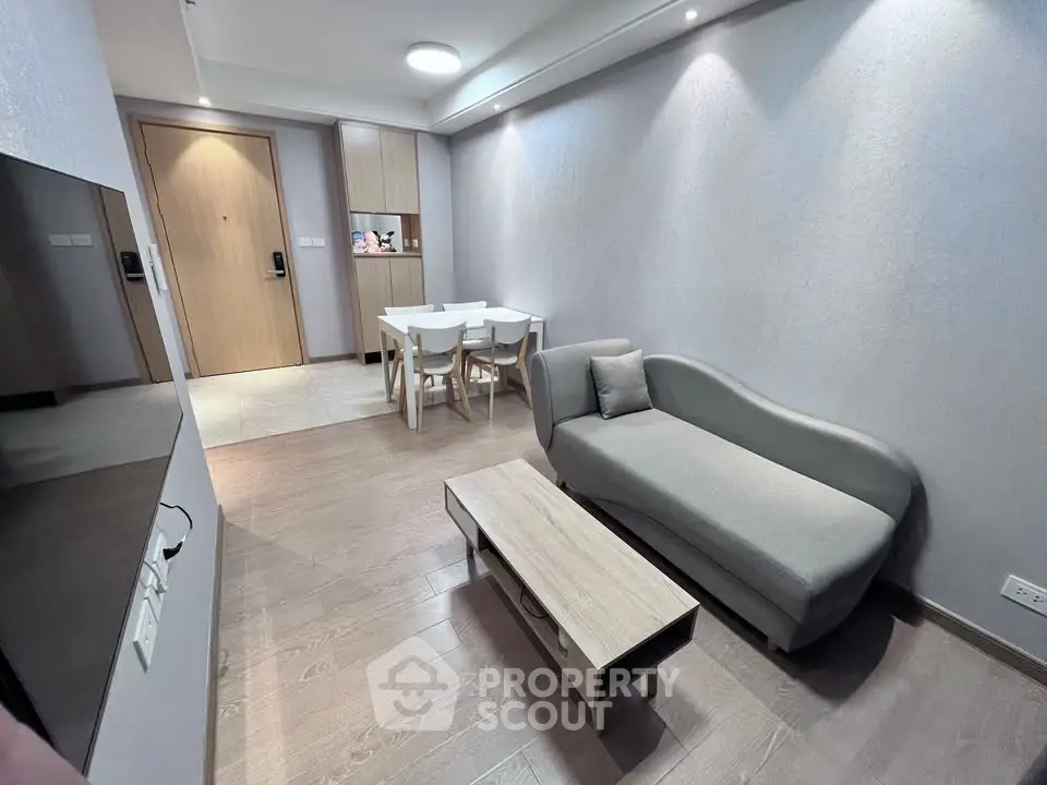 Modern living room with sleek furniture and wooden flooring in a stylish apartment.
