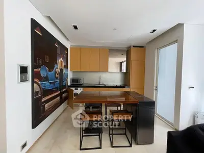 Modern kitchen with sleek design and open layout, featuring wooden cabinets and a stylish dining area.