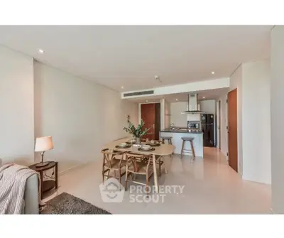 Spacious modern living room with open kitchen and elegant dining area in a stylish apartment.