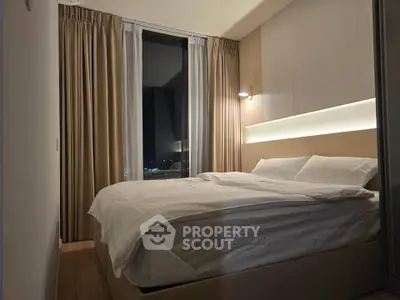Modern bedroom with cozy lighting and city view, featuring elegant curtains and a comfortable bed.