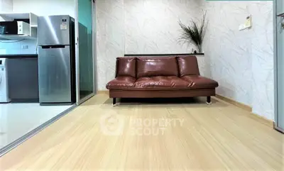 Modern living room with sleek leather sofa and open kitchen layout