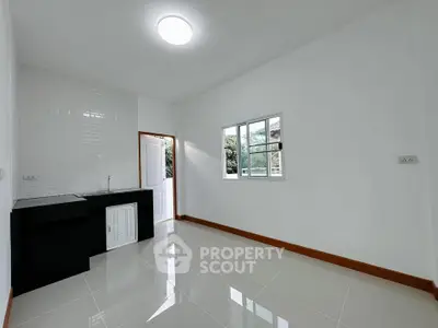 Minimalist kitchen with sleek black countertop and bright natural lighting.