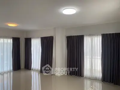 Spacious living room with large windows and elegant curtains
