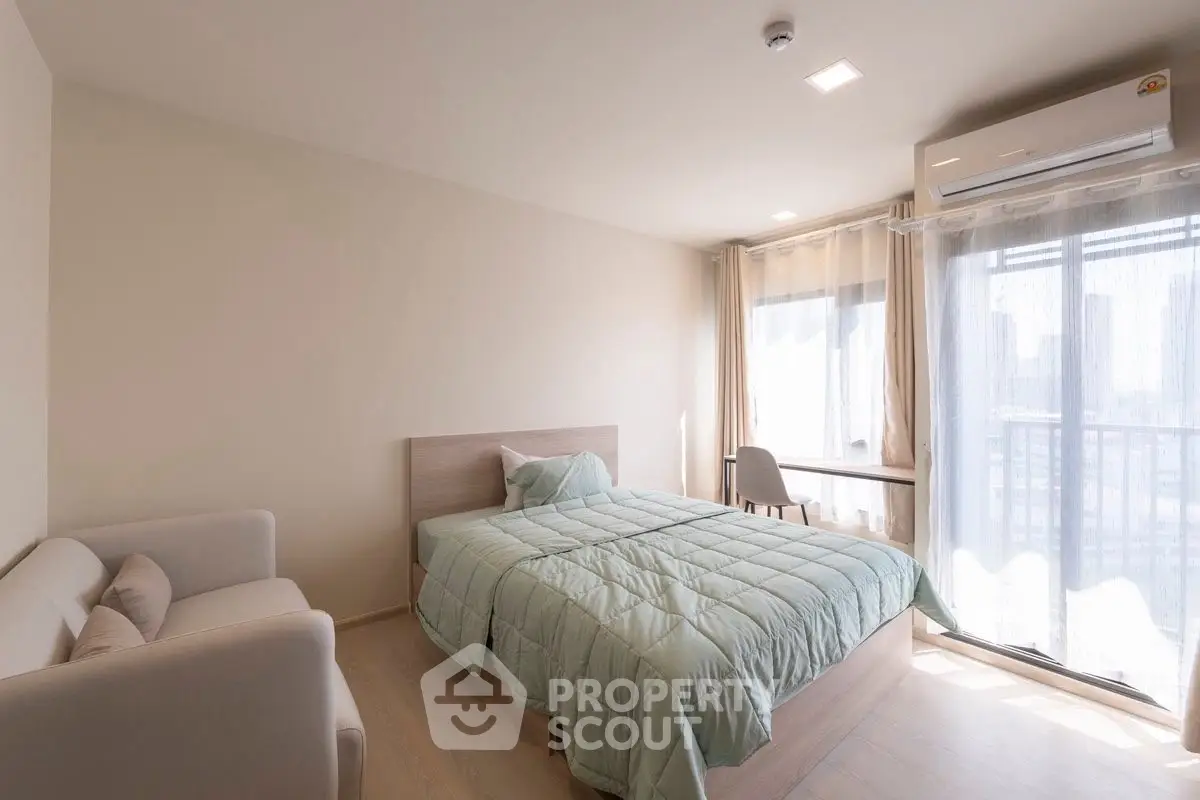 Bright and cozy bedroom with modern furnishings and large window view.