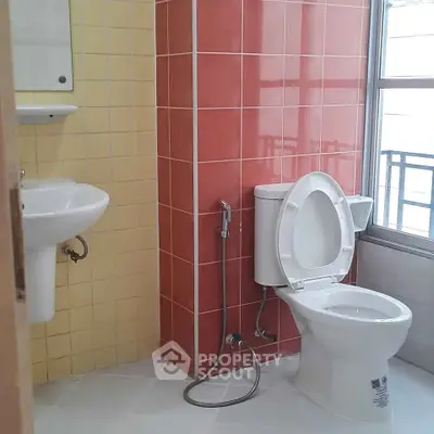 Modern bathroom with colorful tiles and standard fixtures.