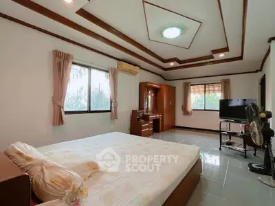 Spacious bedroom with elegant ceiling design and natural light