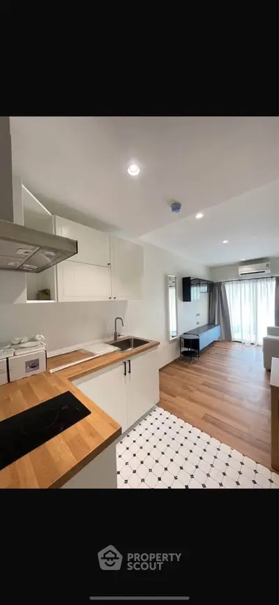 Modern open-layout kitchen with wooden countertops and bright living area