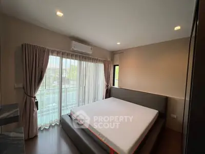 Spacious bedroom with large window and modern decor