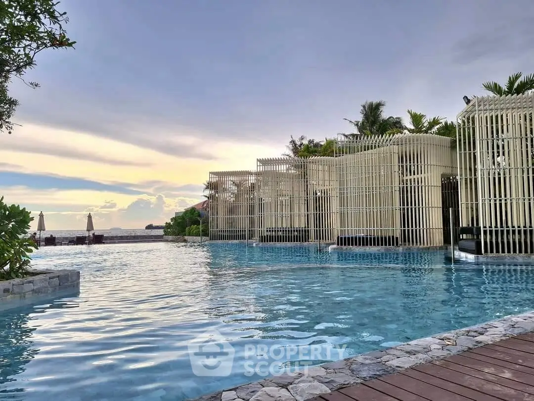 Luxurious poolside view with modern cabanas and serene sunset backdrop.