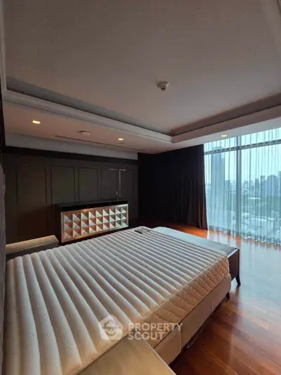 Luxurious bedroom with city view, featuring elegant design and floor-to-ceiling windows.