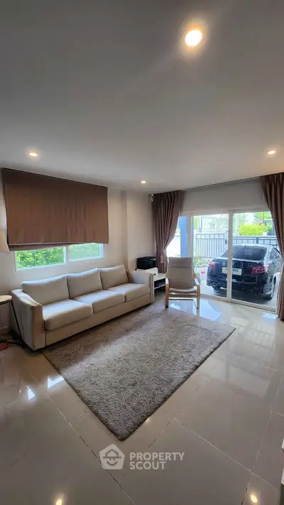 Spacious living room with modern decor and large windows offering natural light.