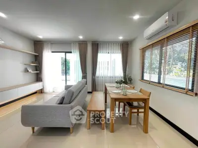 Modern living room with sleek furniture and large windows offering natural light.