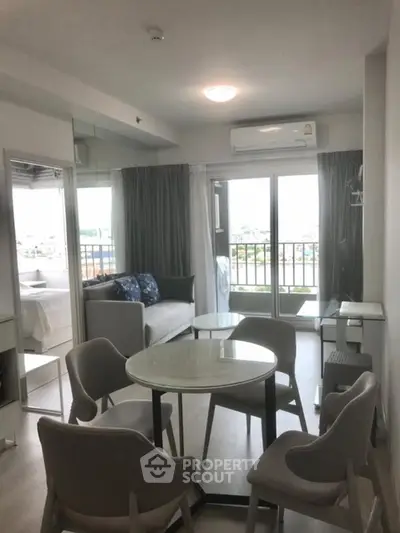 Modern living room with dining area and balcony view in a stylish apartment.