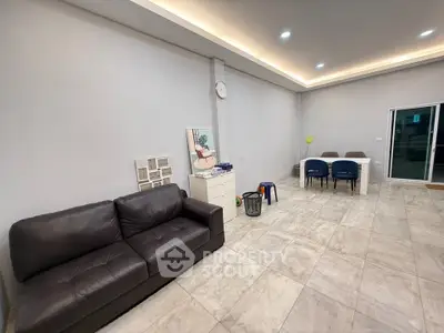 Spacious modern living room with leather sofa and dining area