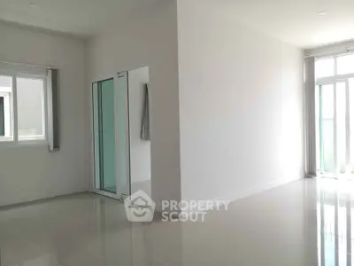 Spacious empty room with large windows and glossy tiled floor, perfect for customization.