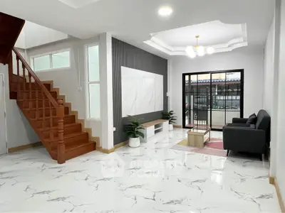 Spacious modern living room with elegant staircase and large windows