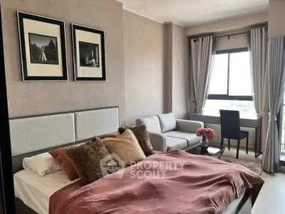 Cozy bedroom with stylish decor, large window, and comfortable seating area.