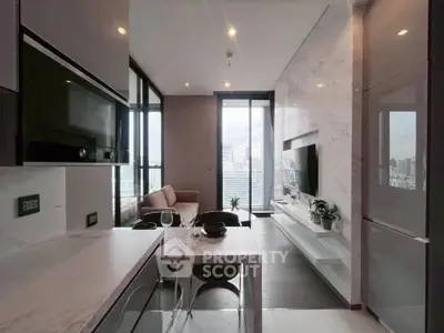 Modern living room with open kitchen and city view, featuring sleek design and natural light.