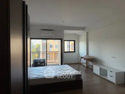 Spacious bedroom with balcony access and modern furnishings in a bright apartment.