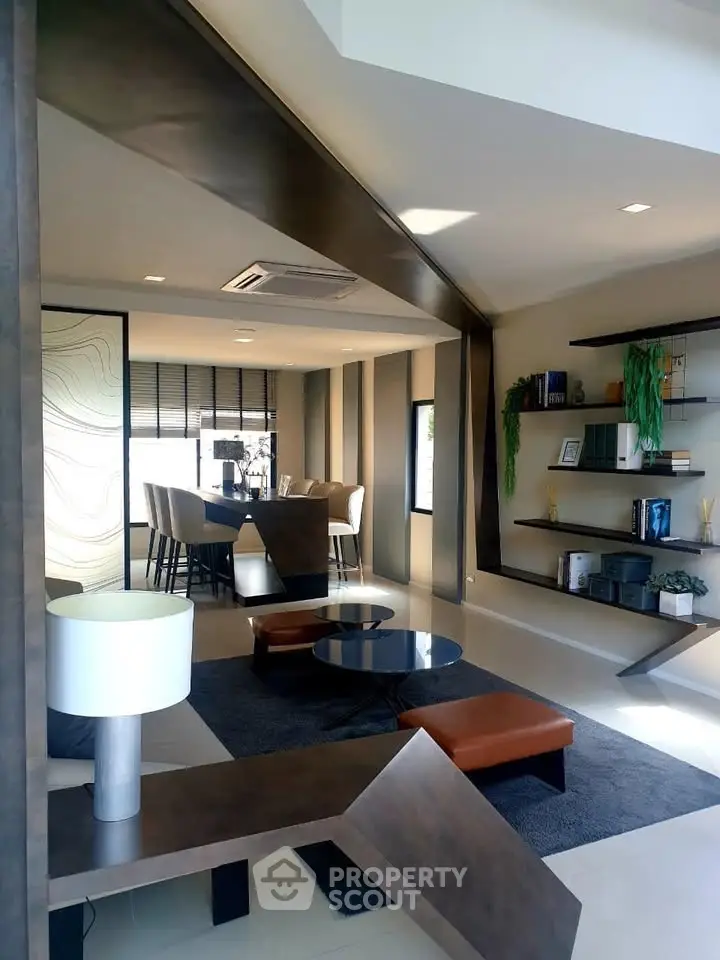 Modern living room with stylish furniture and open layout, featuring a dining area and contemporary decor.