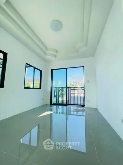 Bright and spacious room with large windows and glossy tiled floor, perfect for modern living.