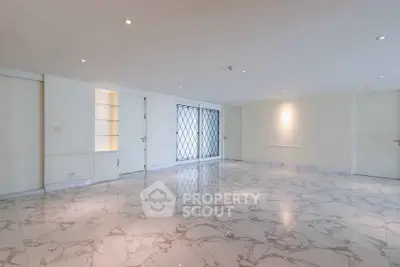 Spacious marble-floored room with elegant lighting and modern design, perfect for luxury living.