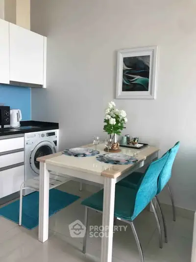 Modern kitchen with dining area featuring washing machine and stylish decor.
