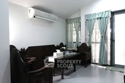 Charming living room with vintage furniture and air conditioning, perfect for cozy gatherings.