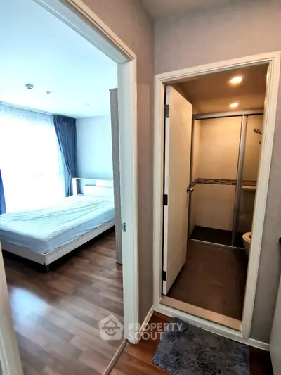 Modern apartment with cozy bedroom and compact bathroom, featuring wooden flooring and bright natural light.