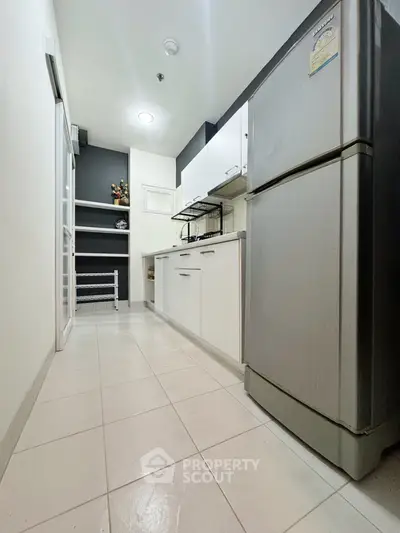 Modern kitchen with sleek appliances and ample storage space in a contemporary apartment.