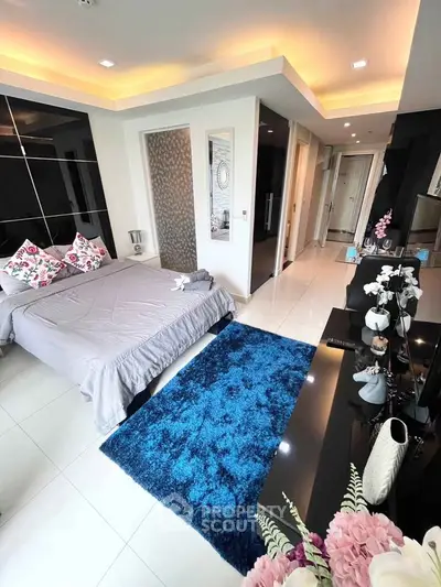 Luxurious modern bedroom with elegant decor and plush blue rug