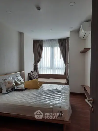 Cozy bedroom with natural light, featuring a comfortable bed and stylish decor, perfect for relaxation.