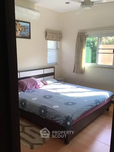 Cozy bedroom with natural light, featuring a double bed and air conditioning, perfect for relaxation.