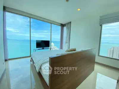 Luxurious bedroom with stunning ocean view and floor-to-ceiling windows