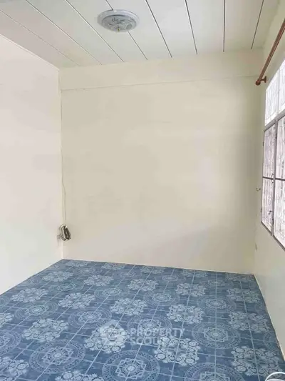 Minimalist room with blue patterned tile flooring and white walls