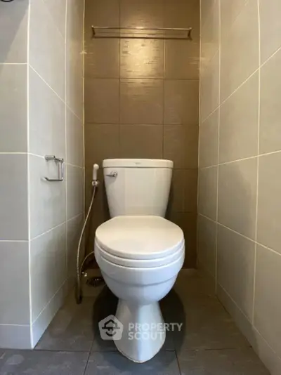 Modern bathroom with sleek toilet and neutral tile design