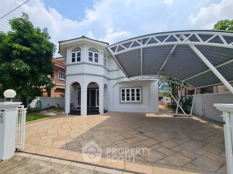 Charming two-story house with spacious driveway and modern carport in a serene neighborhood.