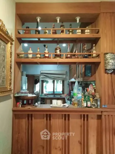 Charming home bar with wooden shelves and elegant decor, perfect for entertaining guests.