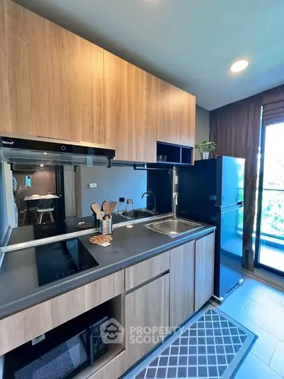 Modern kitchen with sleek wooden cabinets and black appliances in a stylish apartment.