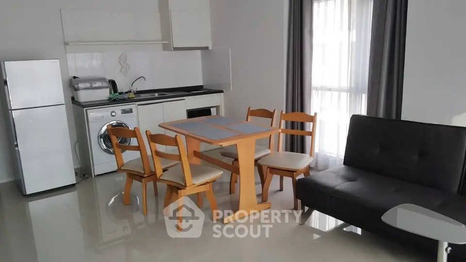 Modern open-plan kitchen and dining area with sleek appliances and stylish furniture.