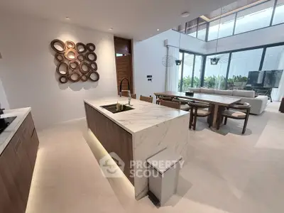 Luxurious open-plan kitchen and living area with modern decor and natural light.